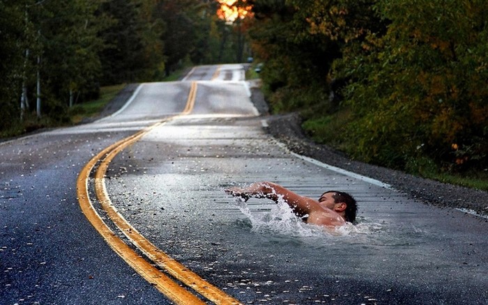Man swimming on a flooded road