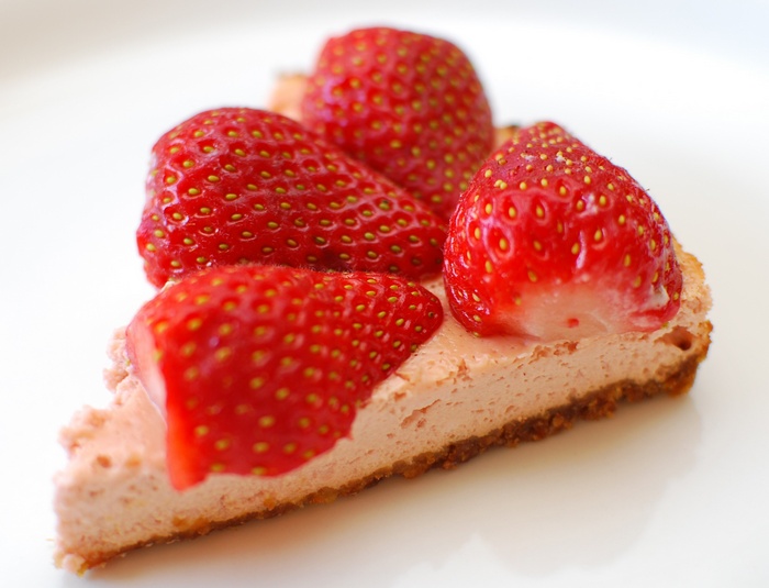 Slice of strawberry cheesecake with fresh strawberries