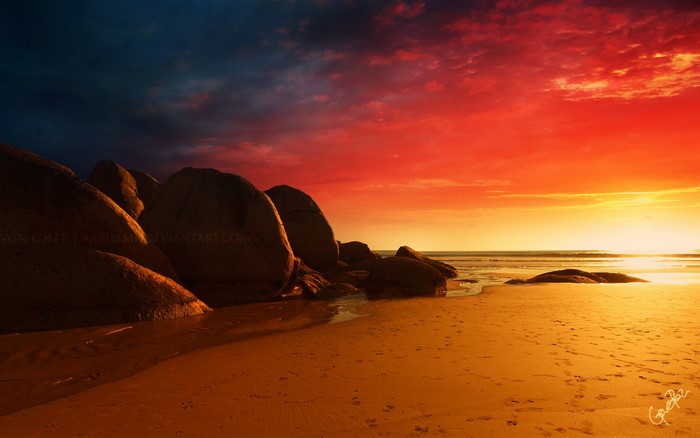 Sunset over a rocky beach with dramatic sky