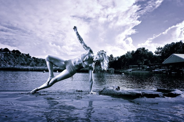 Woman performing yoga on a body of water