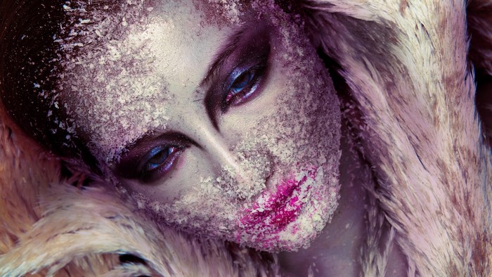 Close up of a woman's face with purple and pink makeup