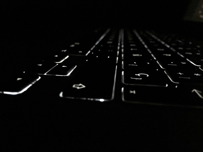 Close-up of a backlit computer keyboard in the dark