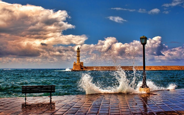 Lighthouse and waves crashing on the shore in Crete