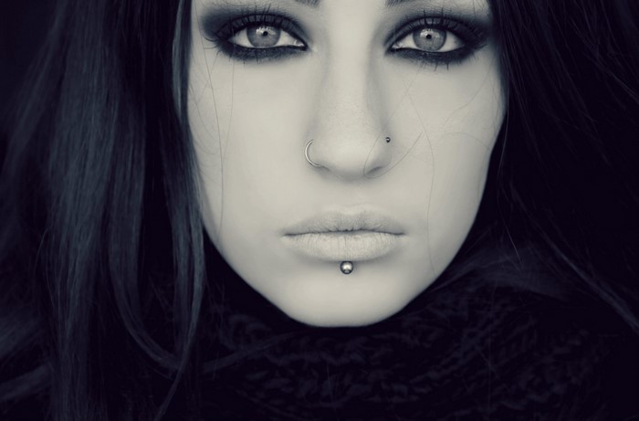 Monochrome portrait of a woman with piercings and dark makeup