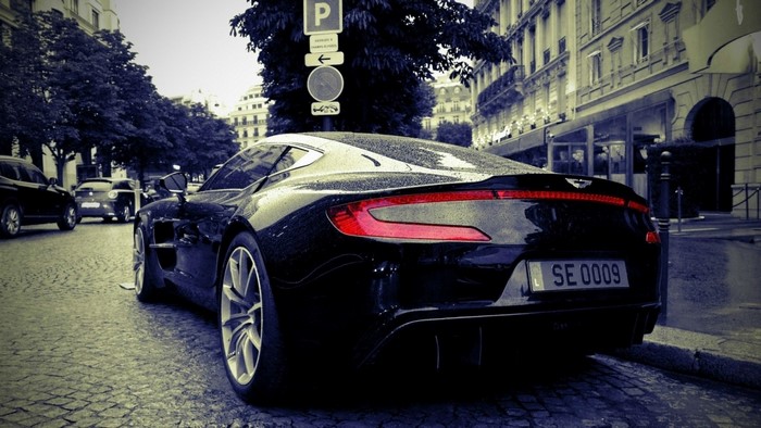 Black Aston Martin Vanquish parked on cobblestone street
