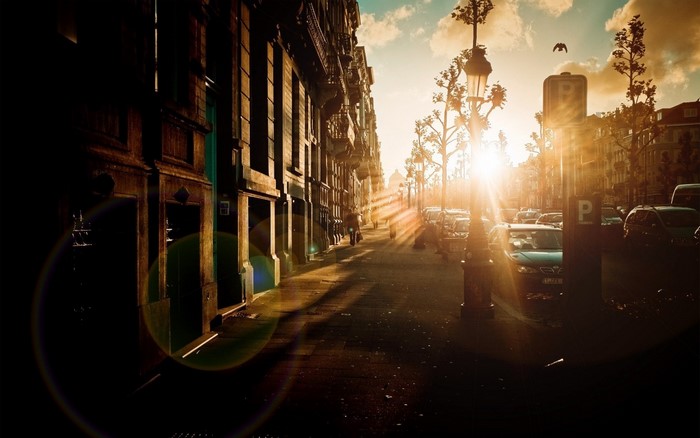 Street scene at sunset with cars and buildings