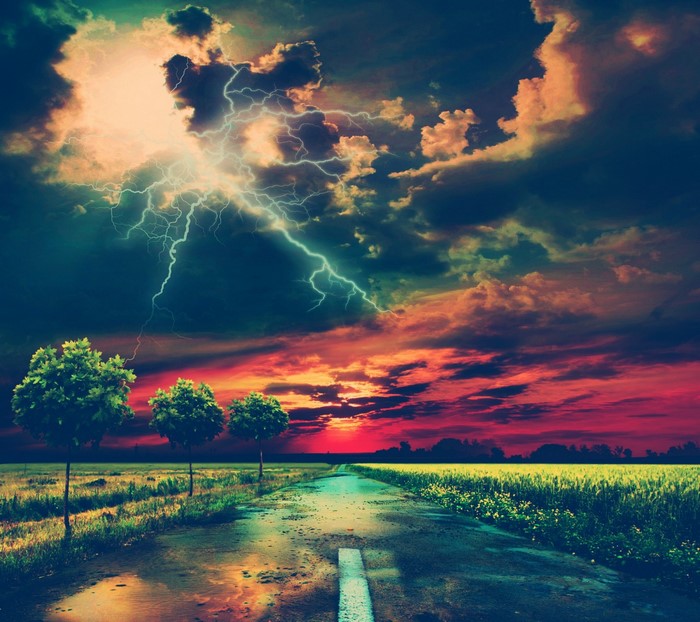 Lightning storm over a road at sunset