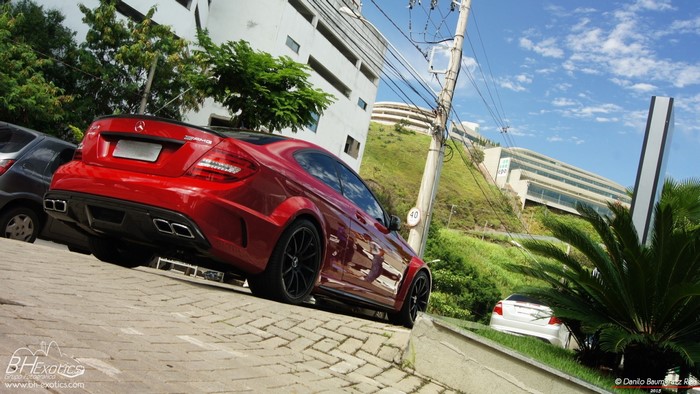 Red Mercedes-Benz C63 AMG Coupe parked on a street