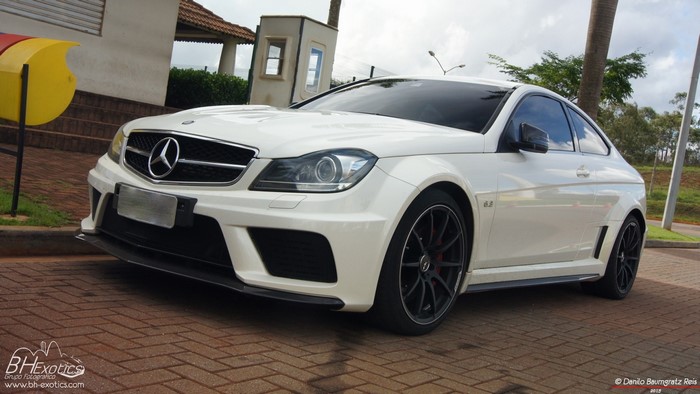 White Mercedes-Benz C63 AMG Coupe parked on brick pavement