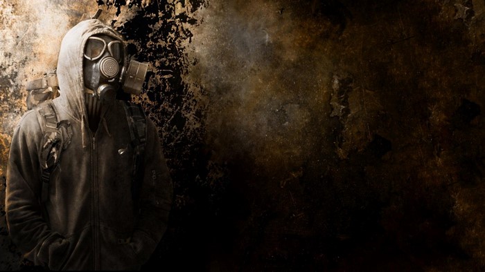 Man in gas mask and hoodie with backpack