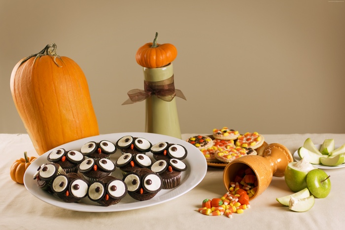 Halloween table with pumpkins, owl cupcakes, cookies, and candy