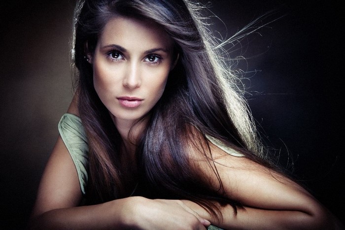 Woman with long brown hair in a studio portrait