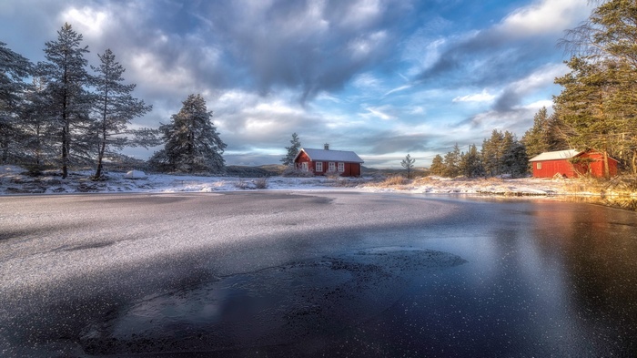 Red cabins by a frozen lake in winter