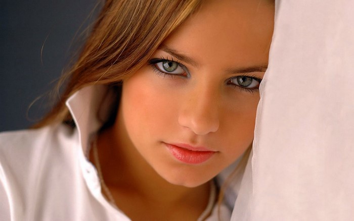 Close-up portrait of a young woman with green eyes