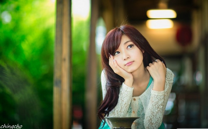 Asian woman resting her chin on her hand