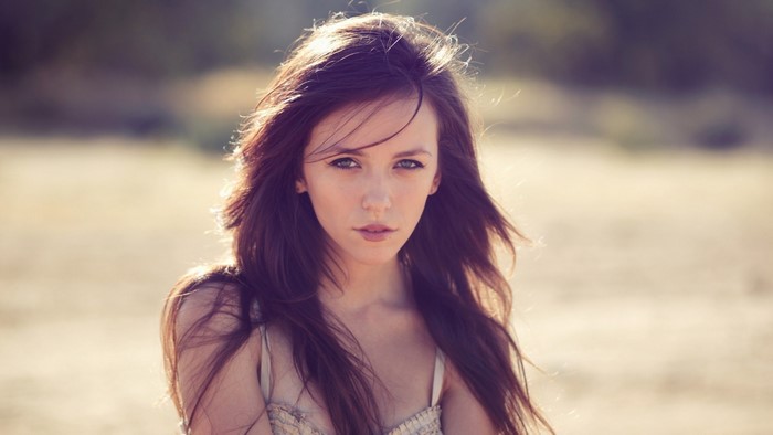 Woman with long brown hair in sunlight