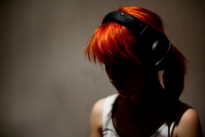 Woman with red hair wearing headphones