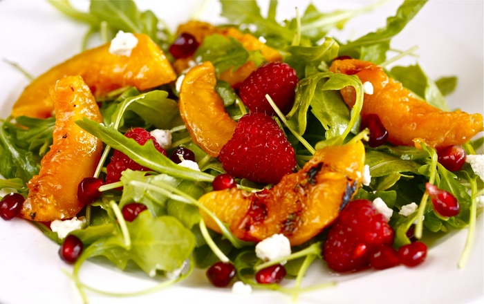 Salad with caramelized nectarines, raspberries, pomegranate, and arugula