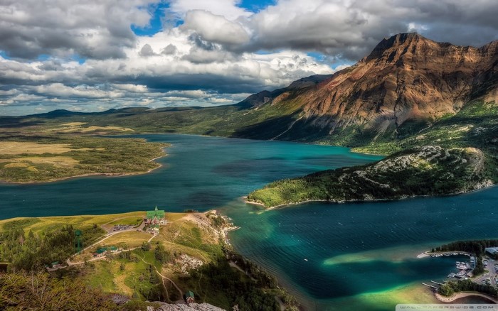 Turquoise lake surrounded by mountains and green hills
