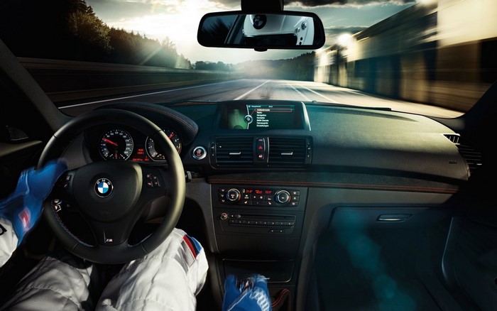BMW M car interior with driver wearing racing gloves