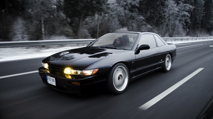 Black Nissan Silvia S13 driving on a snowy road
