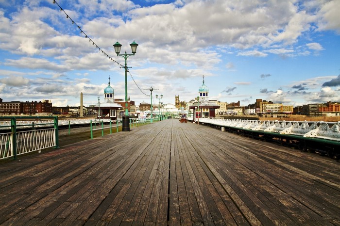 Wooden pier with buildings and cloudy sky