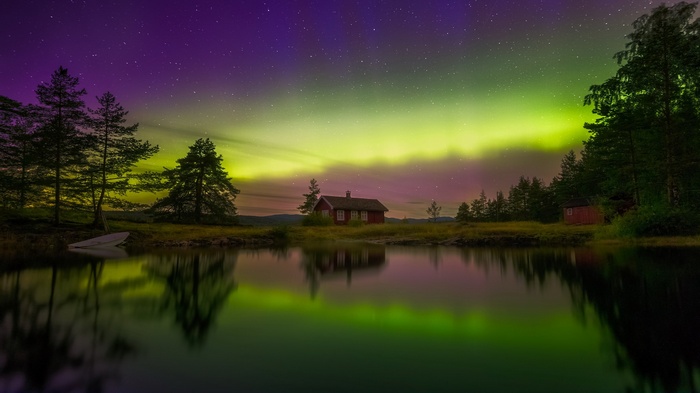 Aurora Borealis over a lake with cabins