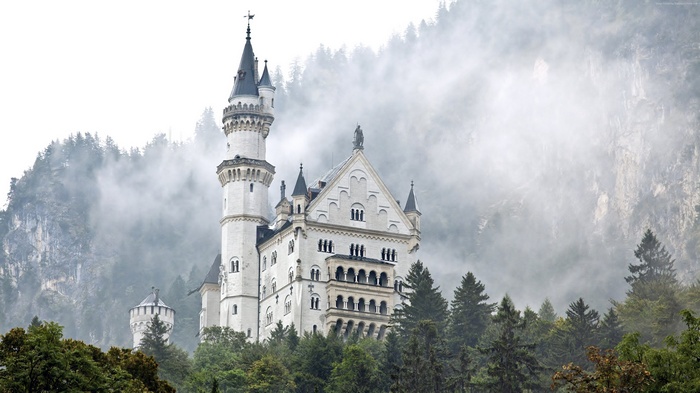 Neuschwanstein Castle in Germany with Foggy Forest