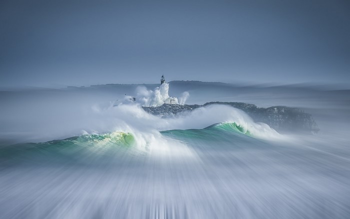 Waves crashing on a lighthouse during a storm