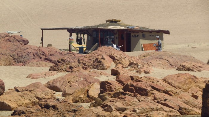 Desert shack with people and rocks