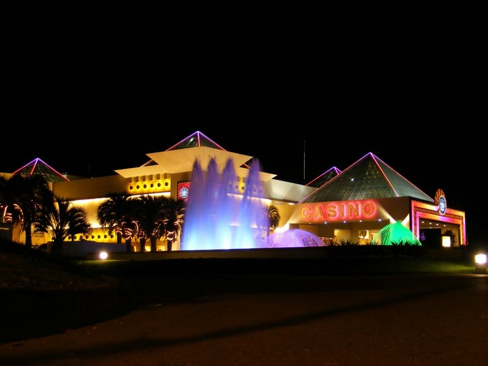Casino building with fountains and palm trees at night
