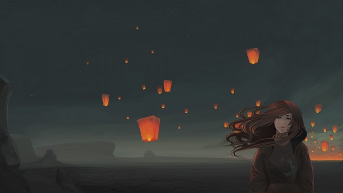 Girl with windblown hair and sky lanterns at night