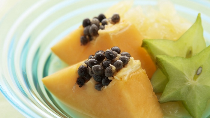 Papaya and star fruit slices in a bowl