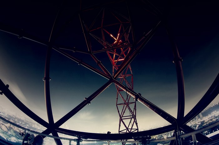 Looking up at a red metal tower structure at night