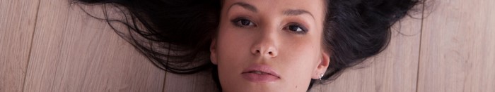 Woman with long brown hair lying on wooden floor