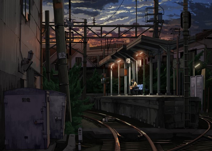 Train station at dusk with a lone figure waiting