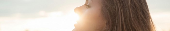 Woman with long brown hair in sunlight