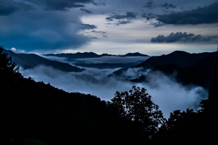 Misty mountains at dusk with dark clouds