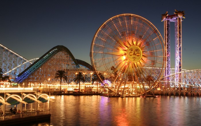 Amusement park at night with Ferris wheel and roller coaster