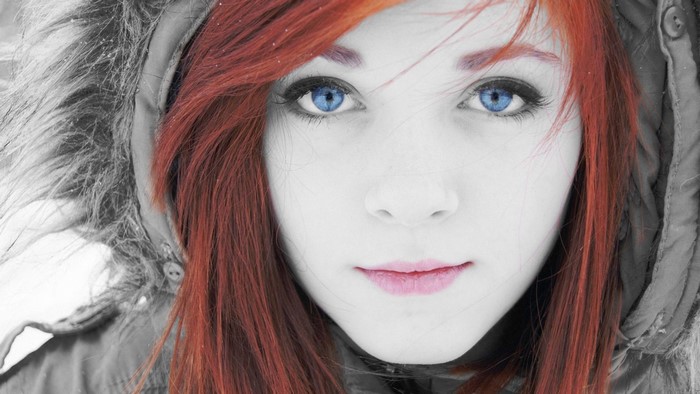 Close up portrait of a young redhead woman with blue eyes