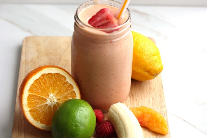 Fruit smoothie with orange, lime, lemon, banana, and strawberry