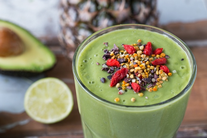 Green smoothie with goji berries, bee pollen, and cacao nibs