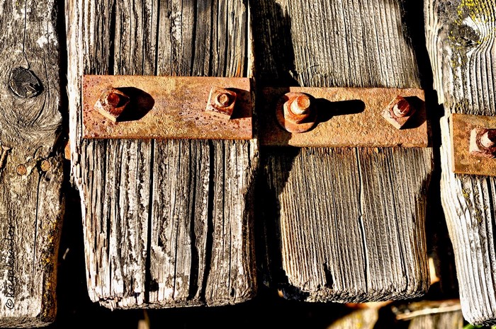 Rusty bolts on weathered wooden planks