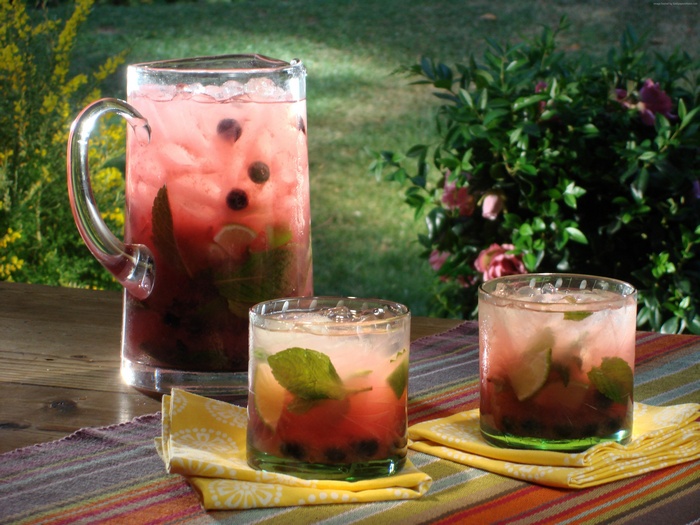 Pitcher and glasses of blueberry mojito cocktails