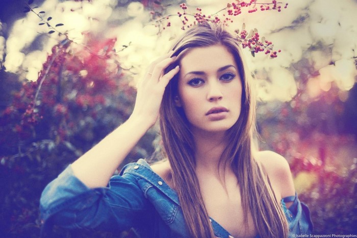Woman with long brown hair and blue jacket in nature