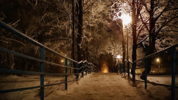 Snowy park path at night with streetlights