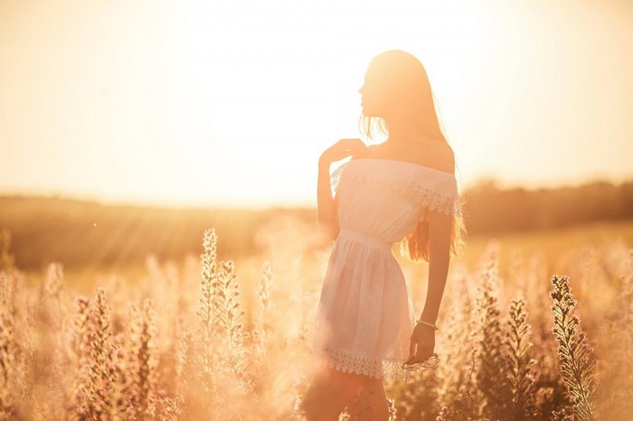 Woman in white dress in a sunlit field