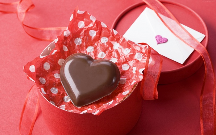 Heart-shaped chocolate in a gift box with a love letter