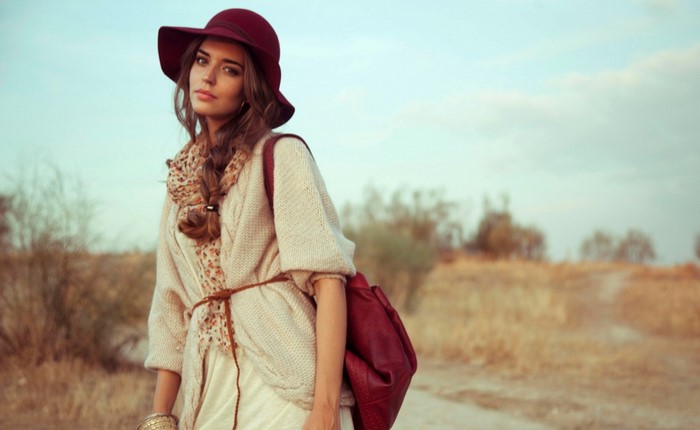 Woman wearing a hat and cardigan in a field