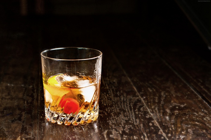 Cocktail with ice, cherry, and lemon slice